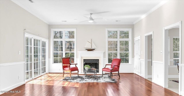 sunroom featuring a ceiling fan and a fireplace