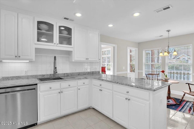 kitchen featuring dishwasher, a peninsula, a sink, and visible vents