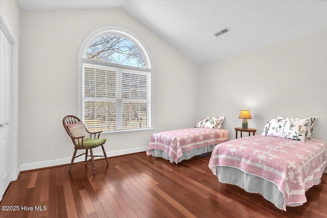 bedroom with lofted ceiling, multiple windows, visible vents, and wood finished floors