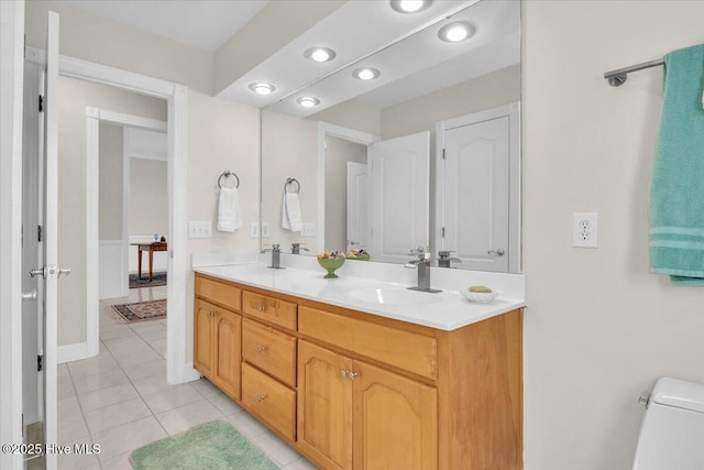 full bathroom featuring double vanity, tile patterned flooring, and a sink