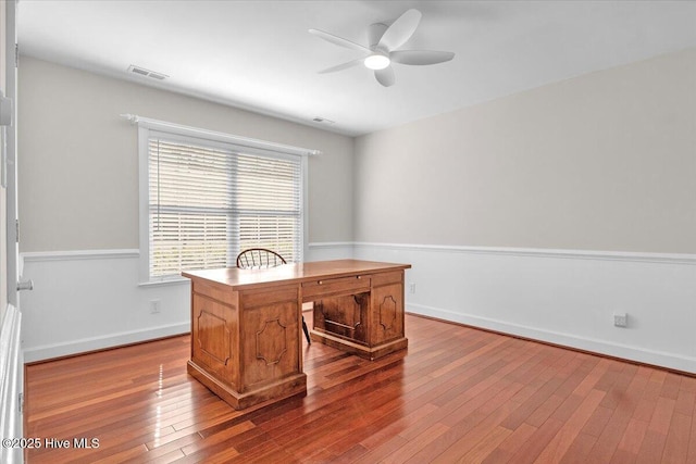 office area with a ceiling fan, baseboards, visible vents, and hardwood / wood-style floors