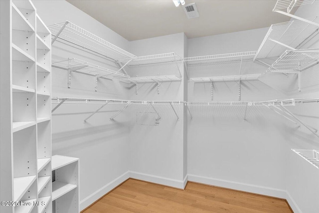 walk in closet with visible vents and wood finished floors