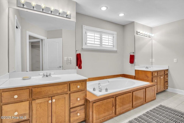 bathroom featuring a garden tub, two vanities, a sink, and tile patterned flooring