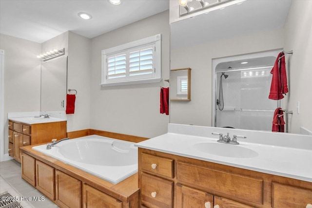 full bath with a garden tub, two vanities, a sink, a shower stall, and tile patterned flooring