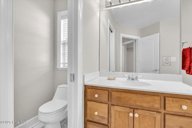 bathroom with plenty of natural light, vanity, and toilet