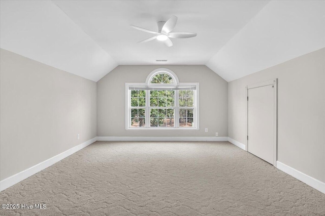 additional living space featuring carpet flooring, vaulted ceiling, baseboards, and ceiling fan