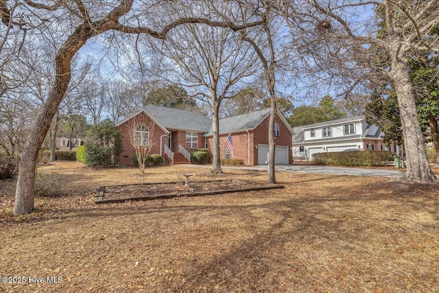 view of front of property with a garage, concrete driveway, brick siding, and crawl space