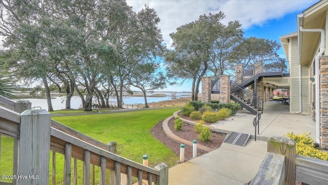 view of yard featuring a water view and stairs