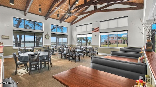 dining area featuring baseboards, wood ceiling, beamed ceiling, carpet, and high vaulted ceiling