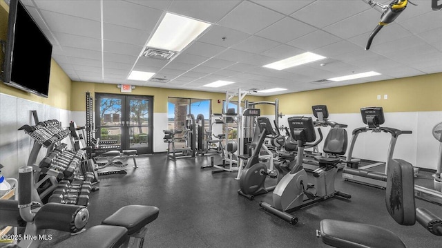 exercise room featuring french doors, a paneled ceiling, and visible vents