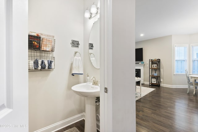 bathroom featuring a fireplace with flush hearth, recessed lighting, wood finished floors, and baseboards