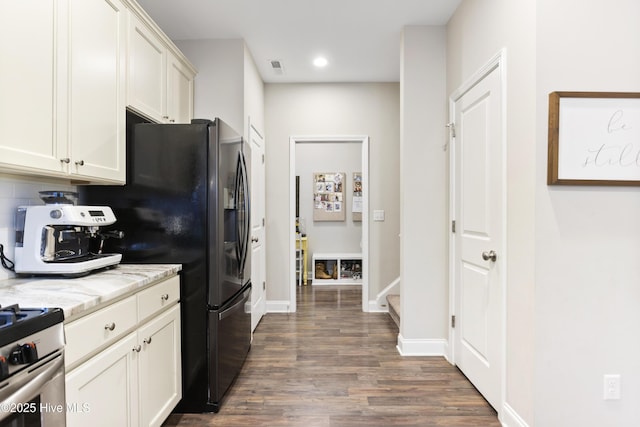 kitchen featuring light stone counters, baseboards, appliances with stainless steel finishes, decorative backsplash, and dark wood-style floors