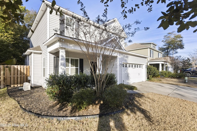 traditional home with a garage, driveway, and fence