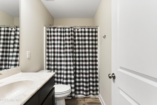 full bath featuring vanity, wood finished floors, toilet, and a shower with curtain