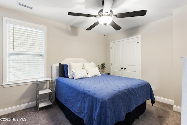 carpeted bedroom featuring a ceiling fan, baseboards, visible vents, and a closet