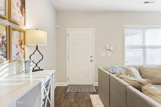 foyer entrance featuring dark wood-style floors, wine cooler, visible vents, and baseboards