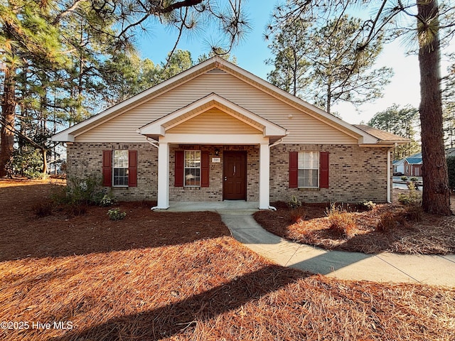 view of front facade with covered porch and brick siding