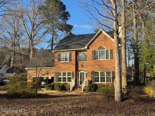 colonial house featuring brick siding