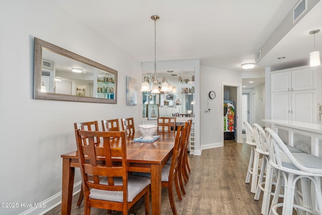 dining room featuring dark wood-style floors, visible vents, and baseboards