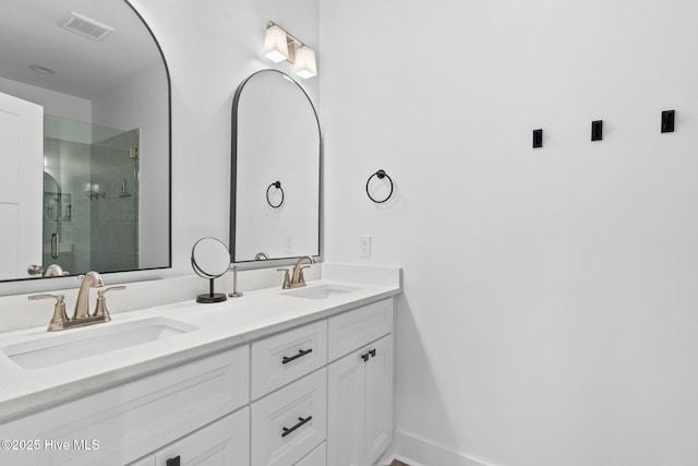 full bath with double vanity, visible vents, a stall shower, and a sink