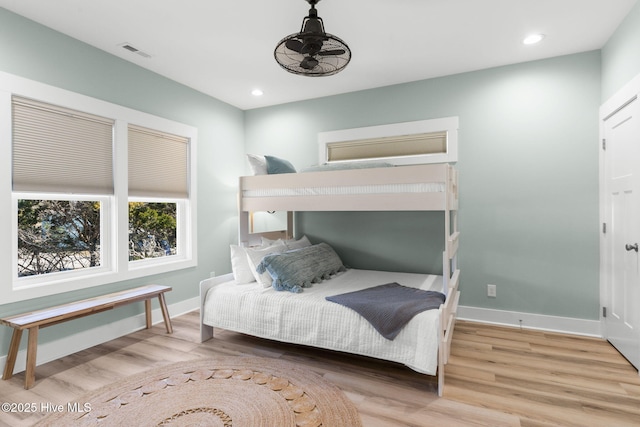 bedroom featuring visible vents, baseboards, and wood finished floors