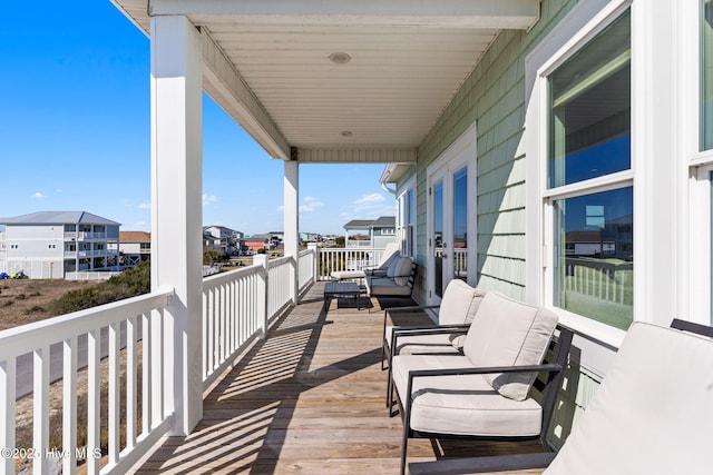 wooden deck featuring a residential view and an outdoor hangout area