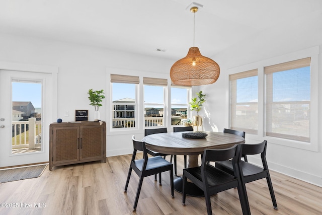 dining area featuring baseboards and light wood-style floors