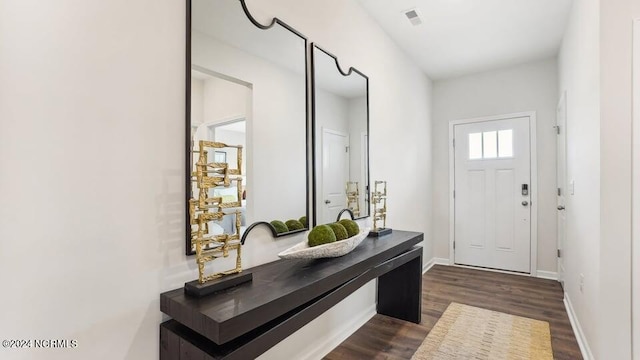 foyer featuring dark wood-type flooring, visible vents, and baseboards