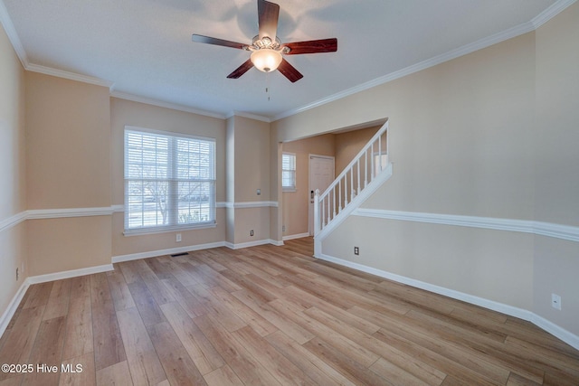 unfurnished room with light wood-style floors, ornamental molding, stairway, and baseboards