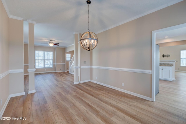 spare room with baseboards, crown molding, stairway, and light wood finished floors