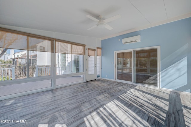 unfurnished sunroom featuring a wealth of natural light, ceiling fan, and a wall mounted AC