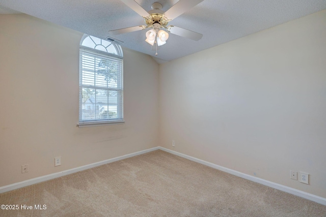 unfurnished room featuring a textured ceiling, lofted ceiling, light carpet, visible vents, and baseboards