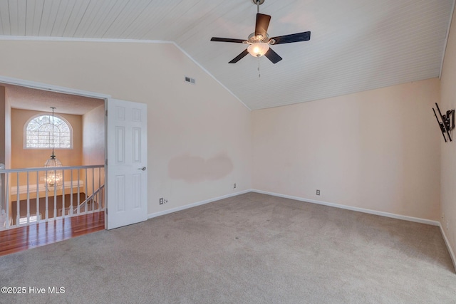 carpeted empty room with visible vents, vaulted ceiling, baseboards, and ceiling fan with notable chandelier