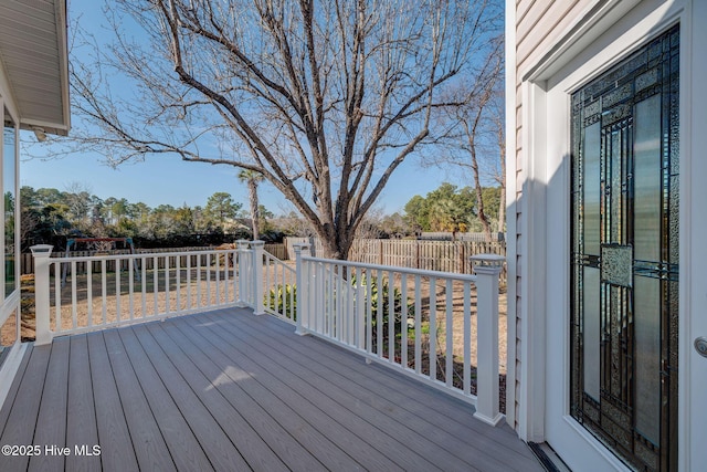 wooden terrace with a fenced backyard