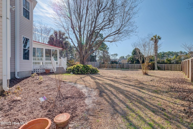 view of yard with a fenced backyard and a sunroom