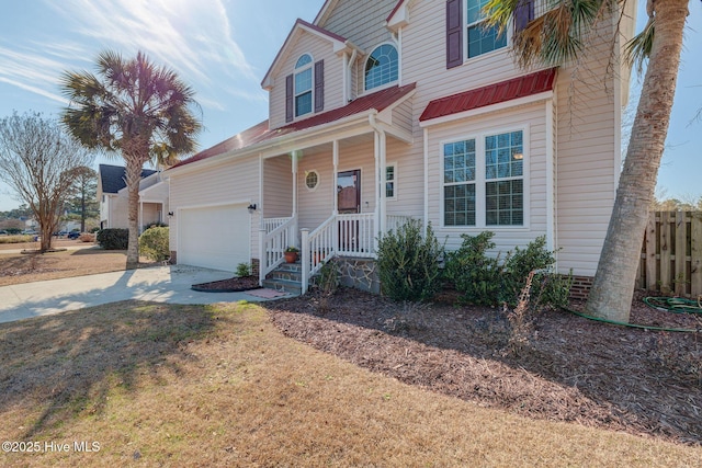 traditional home featuring a garage, covered porch, driveway, and fence