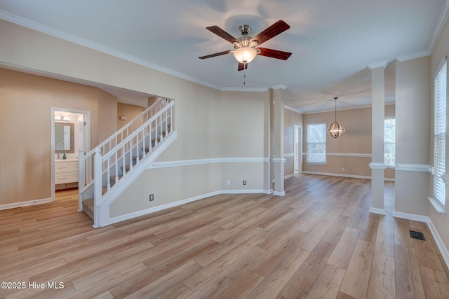 empty room with visible vents, light wood-style flooring, baseboards, and stairs