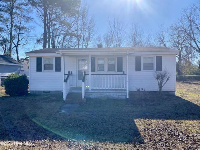 bungalow-style home featuring covered porch, crawl space, and fence