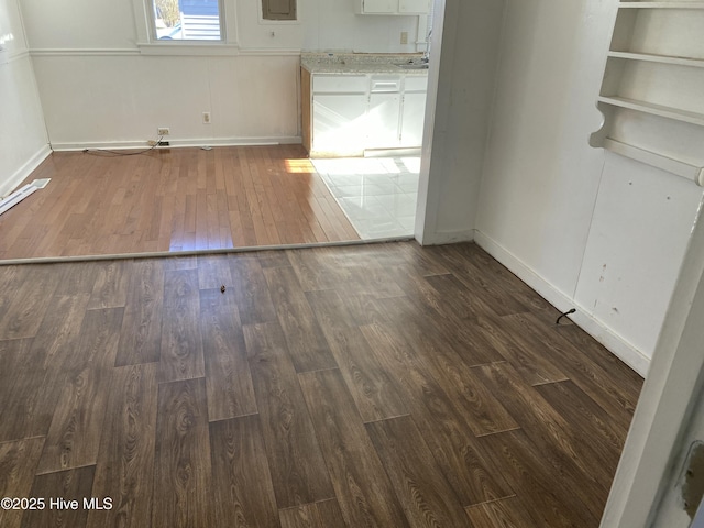 spare room featuring dark wood finished floors and baseboards