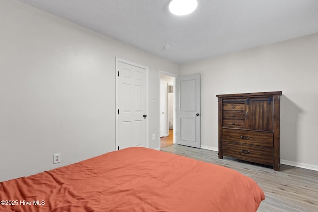 bedroom with baseboards and wood finished floors