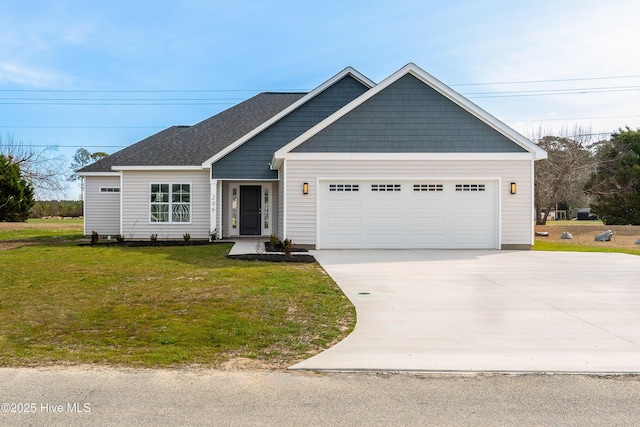 view of front of property with concrete driveway, an attached garage, a front yard, and a shingled roof