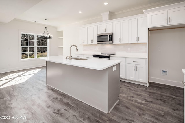 kitchen with white cabinets, appliances with stainless steel finishes, crown molding, and a sink