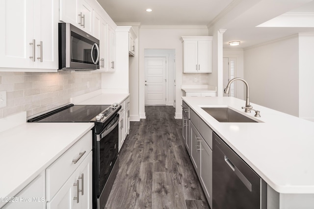 kitchen with a sink, backsplash, appliances with stainless steel finishes, and crown molding