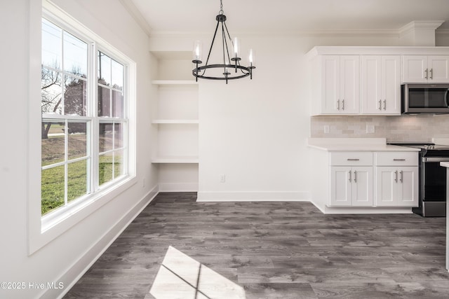 unfurnished dining area featuring a notable chandelier, baseboards, dark wood-type flooring, and crown molding