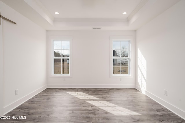 unfurnished room featuring visible vents, a raised ceiling, baseboards, and ornamental molding