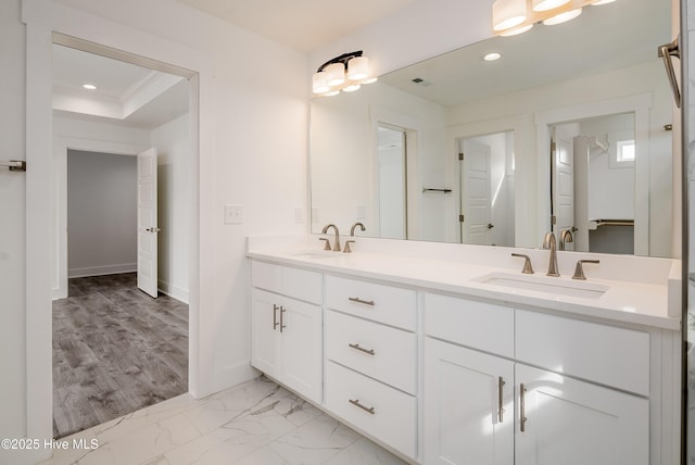 bathroom featuring double vanity, recessed lighting, marble finish floor, and a sink