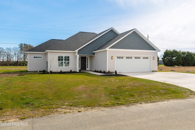 view of front of home featuring a garage, a front lawn, driveway, and a shingled roof