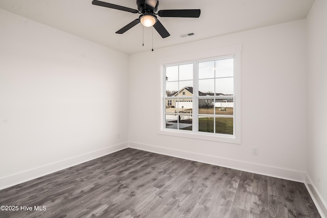 spare room with visible vents, baseboards, ceiling fan, and dark wood-style flooring