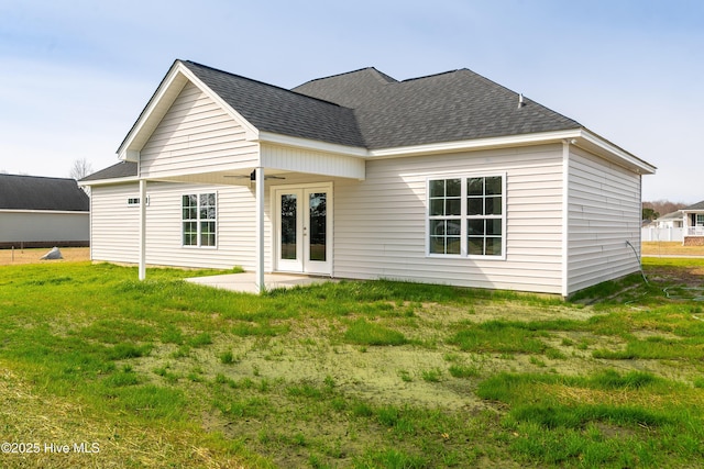 back of property featuring a patio, french doors, a lawn, and roof with shingles