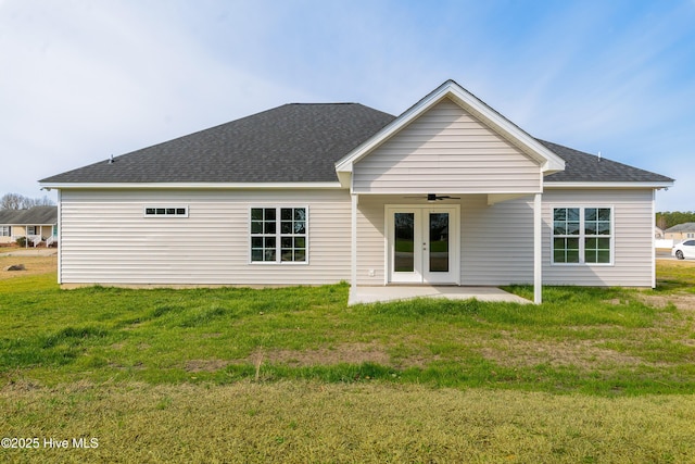 rear view of house featuring a patio, a ceiling fan, a yard, a shingled roof, and french doors